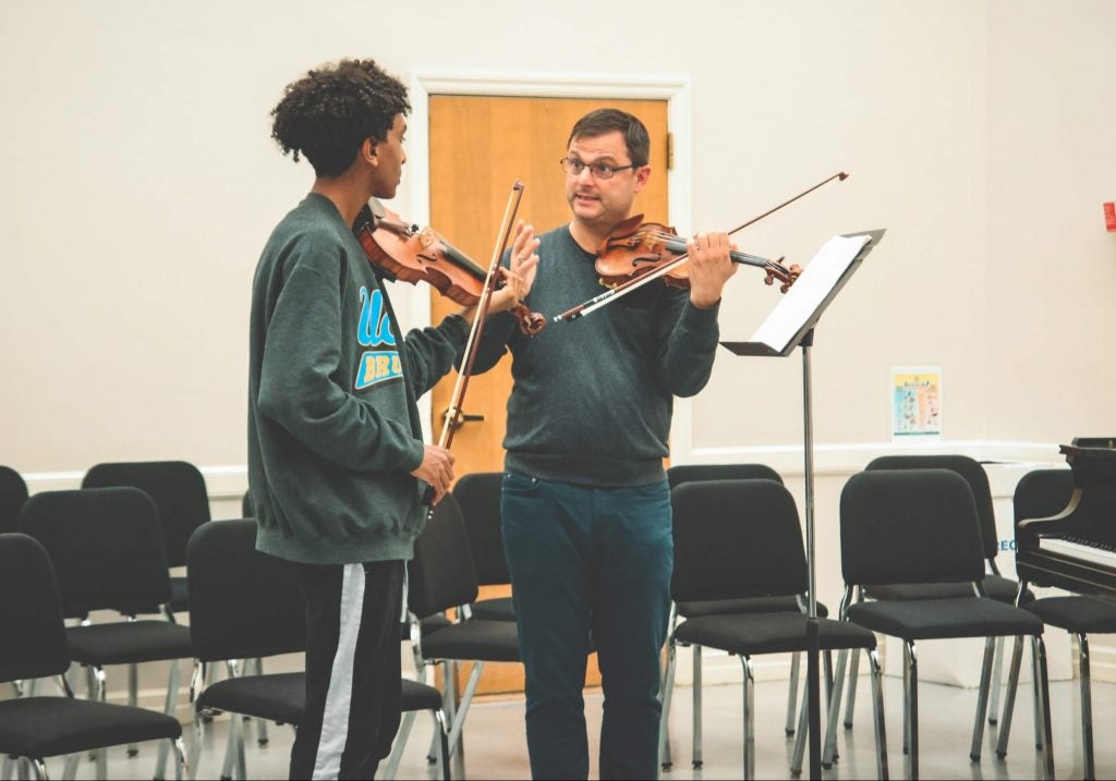 Ara Gregorian teaches a young violinist during a Four Season Next Gen on the Road initiative.