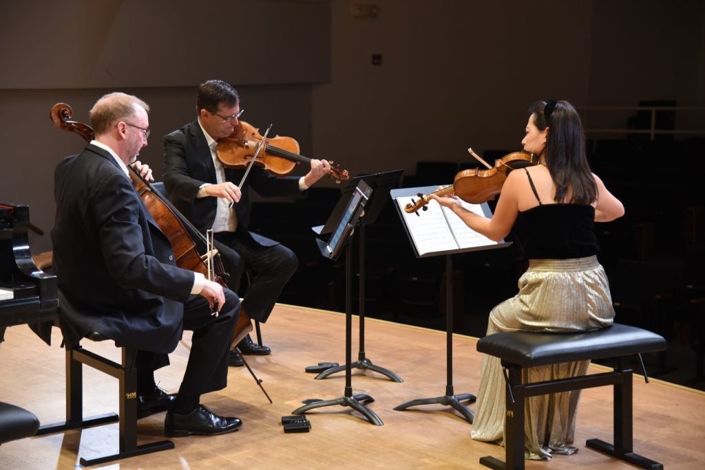 Violinist Hye-Jin Kim, violist Ara Gregorian, and cellist Peter Stumpf warm up ahead of a Signature Series concert in Greenville.